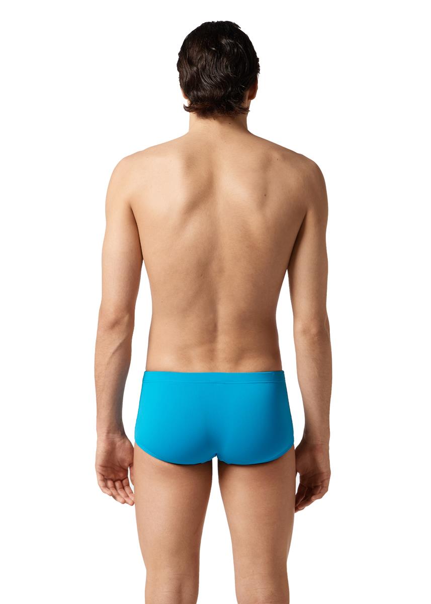 Sprednja stran moškega, ki stoji na boku in nosi kopalke Akron Gus 14cm Trainer Swim Trunk - Montecarlo Blue